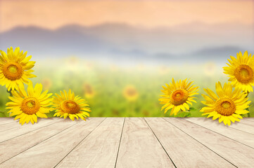 wooden table top with sunflowers  against blurry mountains landscape - Powered by Adobe