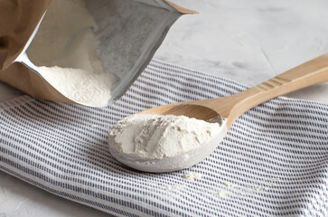 Crumbly xanthan gum in a wooden spoon. - obrazy, fototapety, plakaty