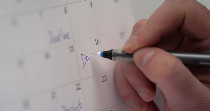 Man's hand wright the text DAY OFF in the calendar