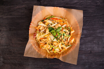 pieces of chicken in salad with stewed vegetables, sesame, greens, served with sauce