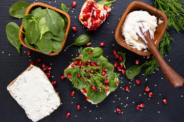 ripe pomegranate grains, young spinach leaves, aromatic dill and fresh cream on a sandwich
