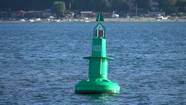 Large green buoy in the sea. Slow motion.