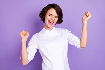 Portrait of attractive cheerful girl having fun celebrating good luck isolated over bright violet purple color background