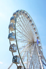 Ferris wheel against the blue sky. Modern Ferris wheel.