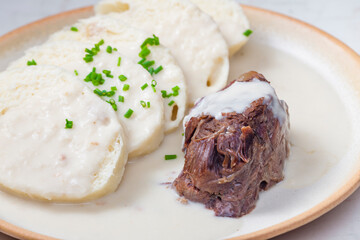 beef meat with white cream sauce and dumplings