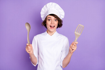Portrait of attractive cheerful chef holding kitchenware homemade domestic cuisine isolated over bright violet purple color background