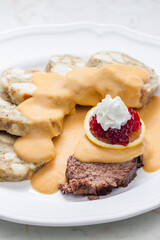 sirloin sauce with dumplings and cranberries on lemon with whipped cream