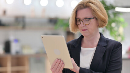 Portrait of Old Businesswoman using Digital Tablet