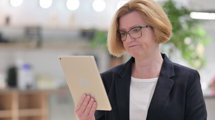 Portrait of Middle Aged Businesswoman having Loss on Tablet