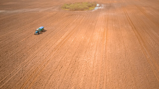 Photo From A Tractor Drone Sowing Seeds In A Field. Process Of Planting Seeds In The Ground As Part Of An Early Spring Agricultural Activity