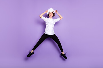 Fototapeta na wymiar Full length body size view of attractive confident cheerful chef jumping having fun isolated over bright violet purple color background