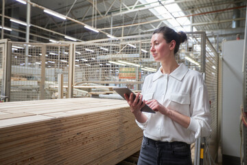 Business woman portrait in the carpentry factory using tablet pc. Carpentry factory. Factory for the production of parquet board
