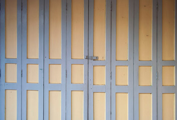 Old Asian wooden doors are yellow and purple.