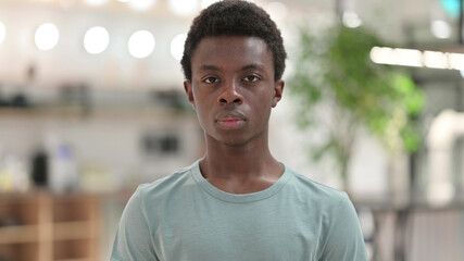 Portrait of Serious Young African Man Looking at Camera