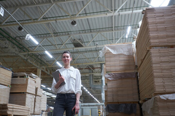 Fototapeta premium Business woman in Industrial Carpentry factory - production of wooden boards with modern machines
