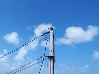 Wooden pole with power lines under tropical blue sky. Bottom view of Wiring on pole, wooden...