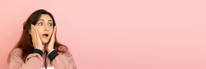 Young woman's portrait on pink studio background. Concept of human emotions, facial expression, youth, sales, ad.