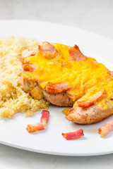 poultry meat baked with bacon and cheese served with couscous
