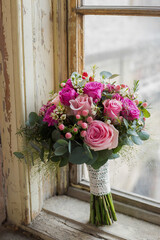 Close up of pink flower bouquet placed in an old wooden vintage window