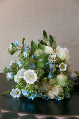 Close up of white, blue and green flower bouquet placed on table