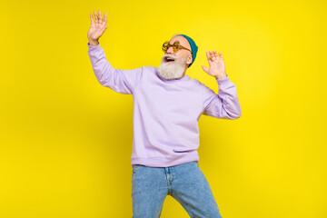 Photo of sweet attractive mature man dressed purple pullover headwear eyewear smiling dancing...