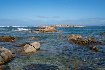 Seagulls on top of a rock on a wild beach in the north of Spain with Cies islands on the background in Galicia