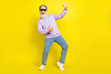 Fototapeta na wymiar Photo of pretty cute mature man dressed purple pullover headwear spectacles dancing playing guitar isolated yellow color background