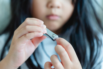 clean nails.kid child girl cutting nails using stainless steel nail clipper at home.Hygiene.virus...