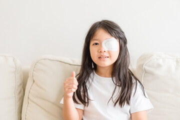 Lazy Eye amblyopia in children.Eye care.Little asian girl covered up with a special patch online learning at home.Occlusion therapy using an eye patch.Children care.child online learning education.