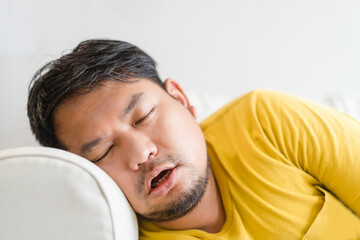 Asian man take a nap on sofa with snore.take nap daydreaming in living rooms snoring.Healthcare...