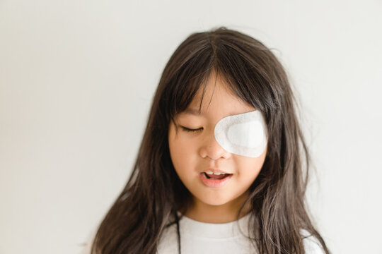 Lazy Eye amblyopia in children.Eye care.Little asian girl covered up with a special patch online learning at home.Occlusion therapy using an eye patch.Children care.child online learning education.