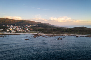 Amazing drone aerial landscape view of mountains in atlantic ocean with waves at sunset in Caldebarcos in Galiza, Spain
