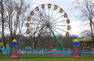 Ferris wheel in the children's town behind the red and blue fence, ulitsa Podvoyskogo, Saint...