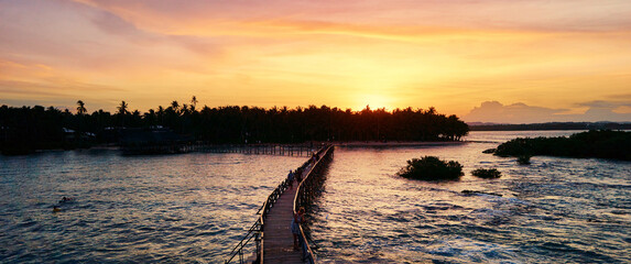 Beautiful landscape. Sunset on the seashore. Wooden bridge on Cloud 9 beach, Siargao Island Philippines. Horizontal photo banner for website header design
