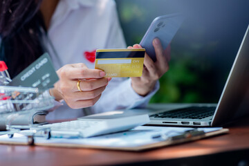 Woman hand using laptop Mockup and credit card for shopping payment online at home.E-commerce and online shopping concept,