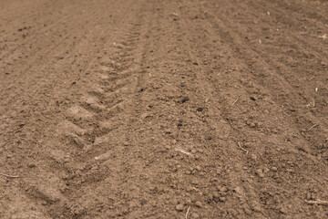 A pure plowed field under the cloudy sky.