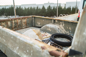 Deshechos y rueda vieja en la parte trasera de una camioneta americana oxidada
