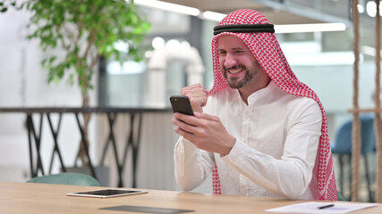 Arab Businessman Celebrating Success on Smartphone