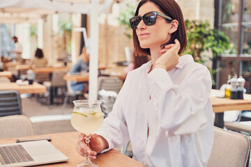 POrtrait of business woman in glasses drinking cocktail