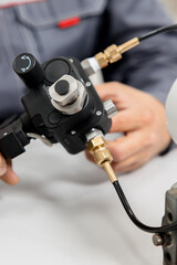 Obraz premium The metrology and standardization laboratory specialist connects the device under test pressure gauge to the pressure calibration and verification instrument. Checking international quality standards