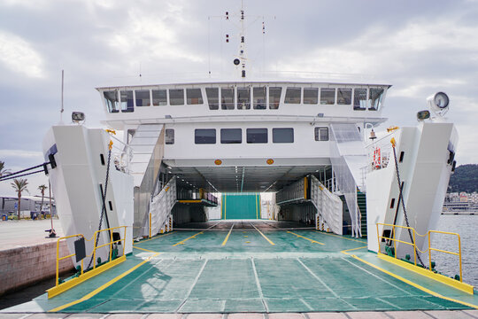 Ferryboat loading or unloading by a port pier. Concept of transportation and traveling.