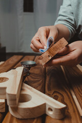 Woman's hands waxing wood. Action close up. Home carpentry concept.