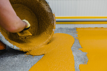 Worker applying epoxy and polyurethane flooring system