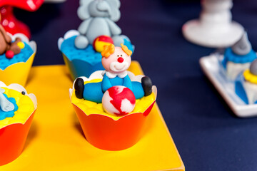 Table with sweets and muffins decorated with Royal icing at a children's party.