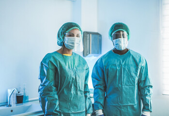 Fototapeta na wymiar Multiracial medical workers wearing hazmat suit and protective face masks inside hospital