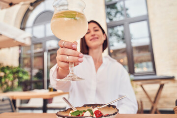 Attractive girl drinking aperol in restaurant cocktail