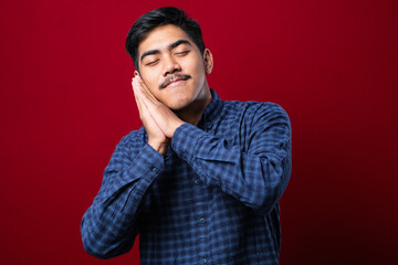 Asian handsome man wearing shirt sleeping tired dreaming and posing with hands together while smiling with closed eyes