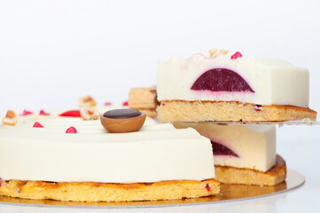 Section of vortex white glazed cake with a candies and chocolate sweets on brown dough. Side image.