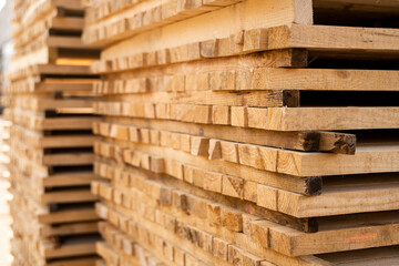 Storage of piles of wooden boards on the sawmill. Boards are stacked in a carpentry shop. Sawing drying and marketing of wood. Pine lumber for furniture production, construction. Lumber Industry.
