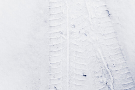 Trace of car tires in the fresh snow. Close up view from above